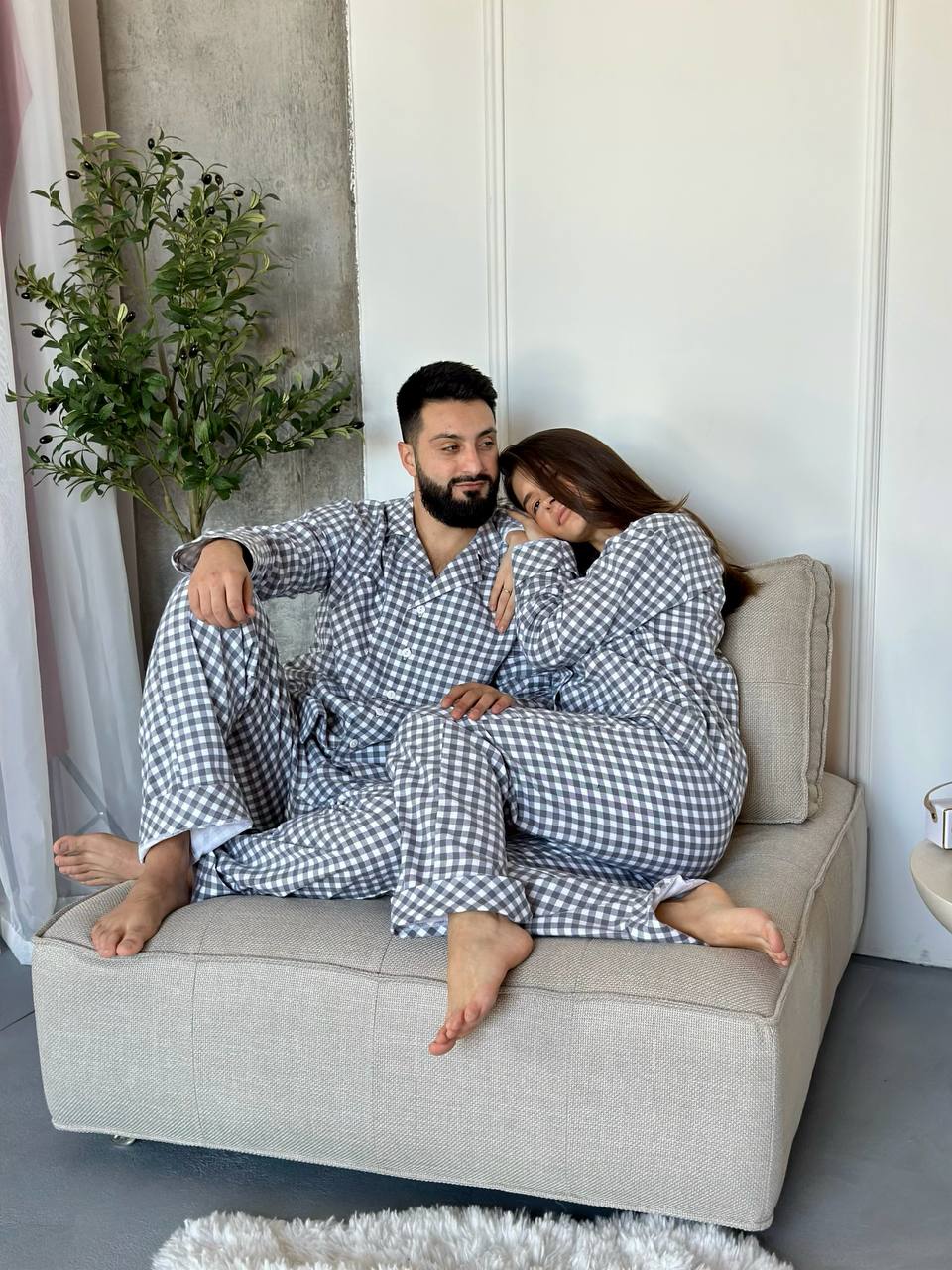 COSY — couple in grey checked pajamas on a sofa